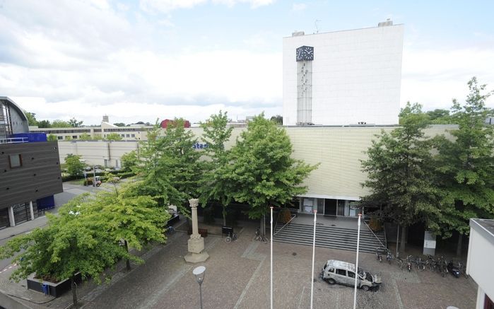 Het stadhuis van Almelo waar een gijzelnemer vijf mensen vast houdt. Op de voorgrond een in de brand gestoken auto. Foto's ANP