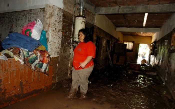 Een Mexicaanse vrouw bekijkt de situatie in haar huis nadat regenval en overstromende rivieren haar huis onder water hebben gezet. Mexico maakt zich op voor storm Dolly. Foto EPA