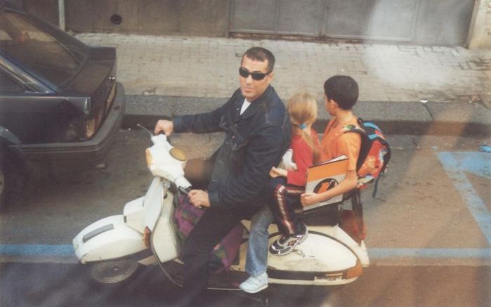 Een Catanees brengt op een oude Vespa zijn kinderen naar school.