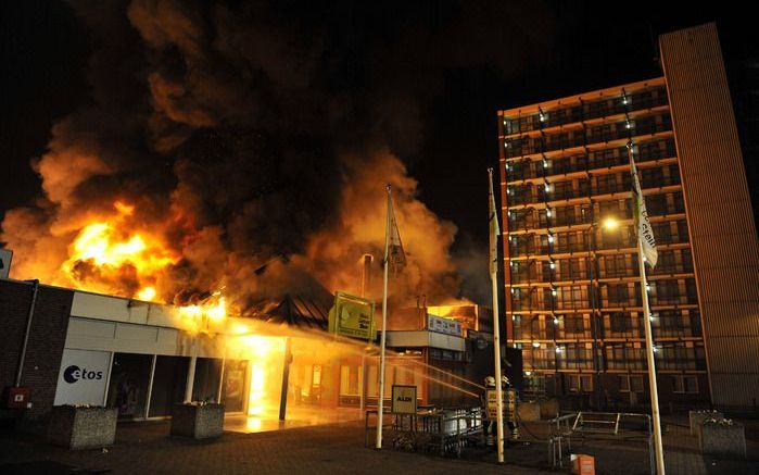 STEIN - Een grote uitslaande brand in een winkelcentrum in Stein kan nog uren duren voordat deze onder controle is. Een flat van elf verdiepingen en zes woonhuizen zijn vanwege de brand ontruimd. Dat meldde de brandweer donderdagmorgen. Foto's ANP