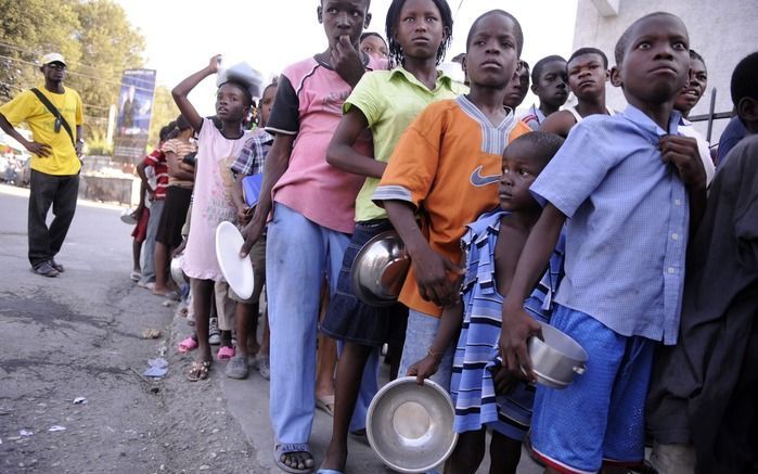 Kinderen wachten op voedsel in de straten van Port-au-Prince. Foto EPA