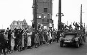 De eerste Duitse troepen komen in 1940 over de Berlagebrug de hoofdstad binnen. Sommige Amsterdammers, onder wie vele NSB’ers, begroeten de bezetters met de Hitlergroet. Foto ANP, Co Zeylemaker