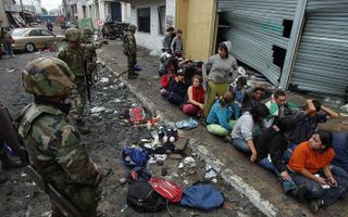 Vreugdenhil: „ Eén keer heb ik iets over onze oude woonplaats gehoord, dat daar weinig slachtoffers zijn, maar dat het er nog erg onveilig is. Zo wordt er veel geroofd.” Foto: Chileense militairen houden een groep plunderaars aan. Foto EPA