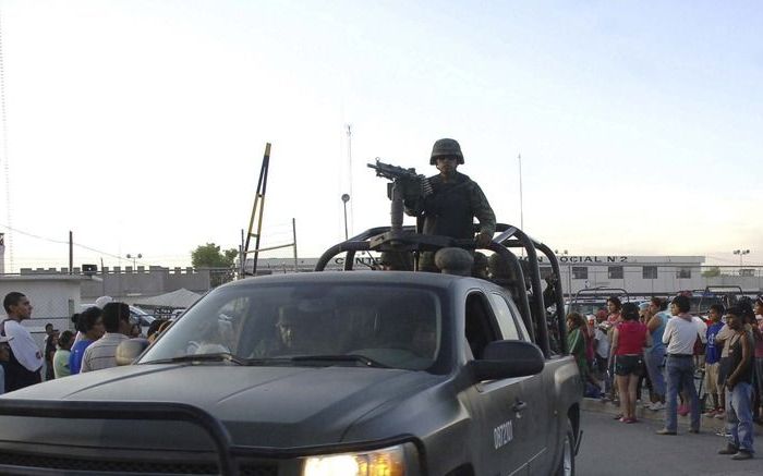 GOMES PALACIO - Een militaire auto bij een gevangenis in het noorden van Mexico. Het leger zou de gevangenis in Gomes Palacio, na onlusten waarbij zeker negentien doden vielen, weer onder controle hebben. Foto EPA