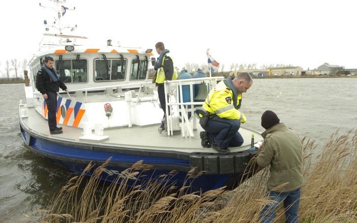 TERNEUZEN – Politiemensen overleggen over de zoekactie naar een auto in het kanaal van Gent naar Terneuzen. Daarbij kwam gisteren een duiker om het leven. Vandaag werd de berging voortgezet. - Foto Willem Woznitza