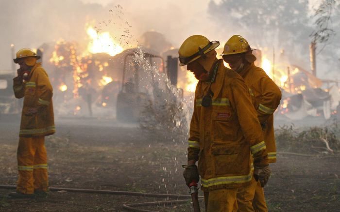 LABERTOUCHE - Medewerkers van de vrijwillige brandweer ruimen hun brandslang op nadat ze een huis hebben geblust nabij Labertouche, ongeveer 125 km ten westen van Melbourne. Foto ANP