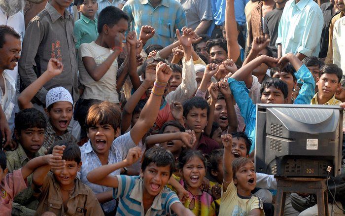 Slumkinderen in Bombay kijken enthousiast naar de uitreiking van de Oscars aan hun vriendjes. Foto EPA