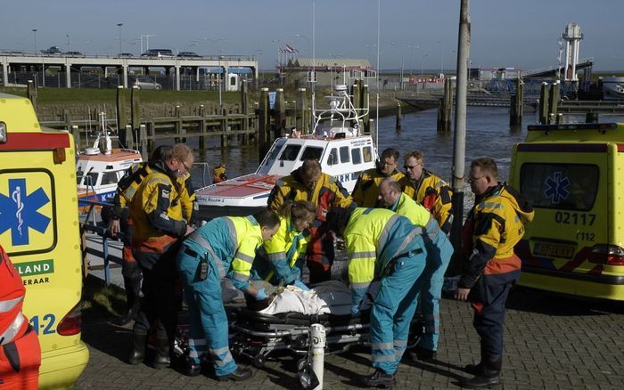 LAUWERSOOG - Een uit de Waddenzee geredde drenkeling wordt door de KNRM in Lauwersoog afgeleverd bij een gereedstaande ambulance. - Foto KNRM