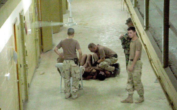 Een foto laat Amerikaanse militairen zien die zich in de Abu Ghraib-gevangenis te buiten gaan. Foto EPA