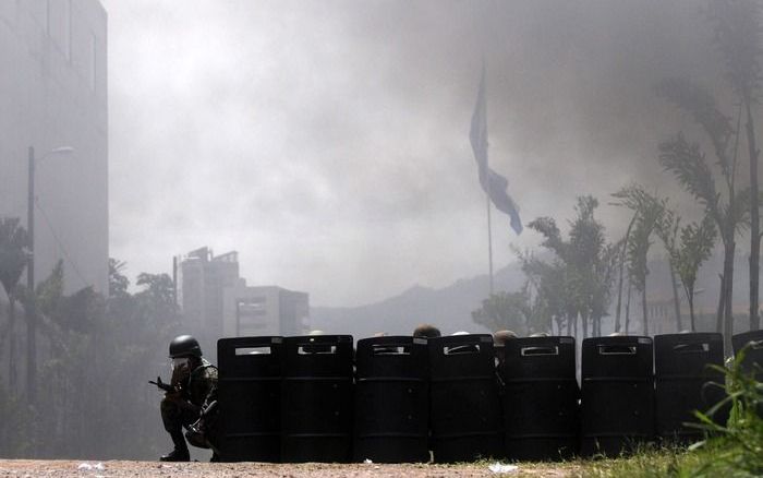 TEGUCIGALPA – Hondurese politie blokkeerde maandag de weg naar het presidentiële paleis in Tegucigalpa. Aanhangers van president Zelaya waren de straat opgegaan. Foto EPA