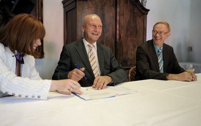 MIDDELBURG – De Zeeuwse gedeputeerde A. J. G. Poppelaars (Financiën) zet zijn handtekening onder de levering van de aandelen NV Westerscheldetunnel. Foto Willem Mieras