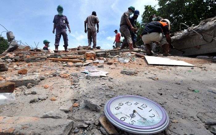 PADANG - Reddingswerkers in Sumatra vinden tussen het puin een klok, die bleef hangen op het moment van de beving. Foto EPA