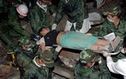 CHINA - Een slachtoffer wordt door reddingswerkers uit de resten van een school gehaald. Foto EPA