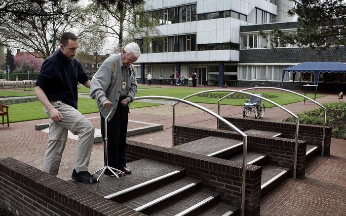 ROTTERDAM - Een man oefent met een begeleider op een trap in de revalidatietuin in Rotterdam. Foto ANP