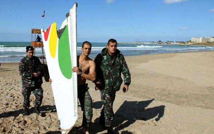 Reddingswerkers dragen een stuk van de gecrashte Boeing van Ethiopian Airlines op het strand van Libanon. Foto EPA