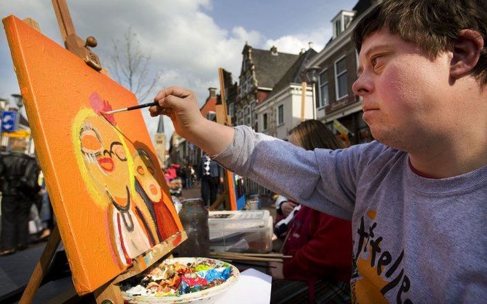 Een verstandelijk gehandicapte jongeman maakt een schilderij voor koningin Beatrix. Dinsdag nam hij deel aan een generale repetitie voor Koninginnedag. Koningin Beatrix en andere leden van de koninklijke familie bezoeken dit jaar de Friese plaatsen Makkum