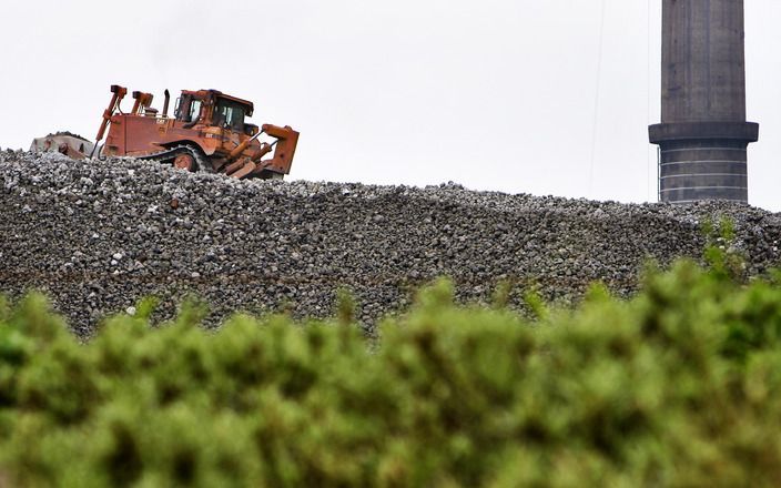 Diep in de haven van Rotterdam ligt heel veel ijzererts. Die bergen, in de Dintelhaven ver voorbij Rozenburg, worden er binnenkort niet kleiner op. Het ijzer is bestemd voor de Duitse auto-industrie. En zolang de vraag naar auto’s stagneert, blijven die b