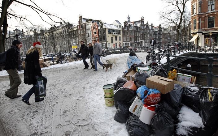 AMSTERDAM - Vuilnis blijft maandag liggen in het centrum van Amsterdam. Door de sneeuw hebben vuilnisauto's moeite de plaatsen te bereiken waar het vuilnis wordt aangeboden. Foto ANP