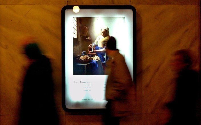 AMSTERDAM - Voorbijgangers in de passage onder het Rijksmuseum passeren het Melkmeisje van Vermeer. Foto ANP