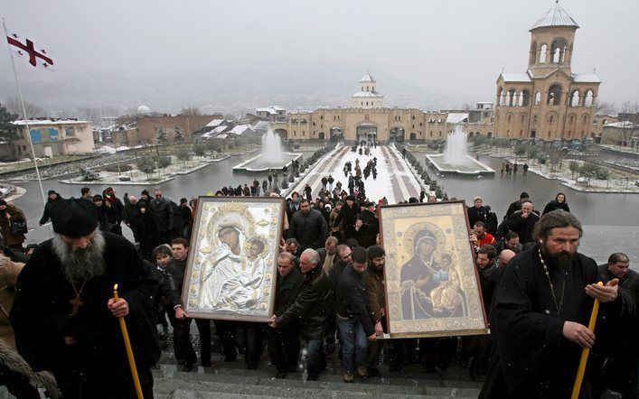 TBILISI – Inwoners van de Georgische hoofdstad Tbilisi dragen iconen naar de Drie-eenheidkathedraal aan de vooravond van de presidentsverkiezingen. In de traditie van de Orthodoxe Kerk leidt het in processie dragen van iconen en kruisen door de straten va