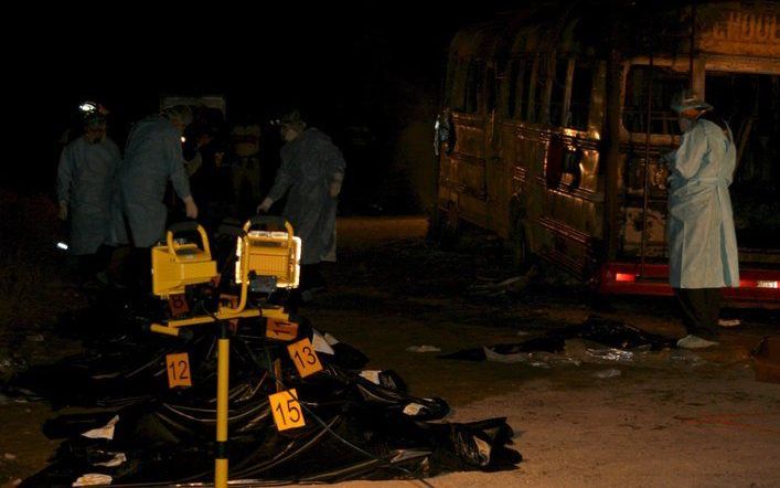 De uitgebrande bus in Guatemala, links de lichamen van omgekomen passagiers. Foto EPA