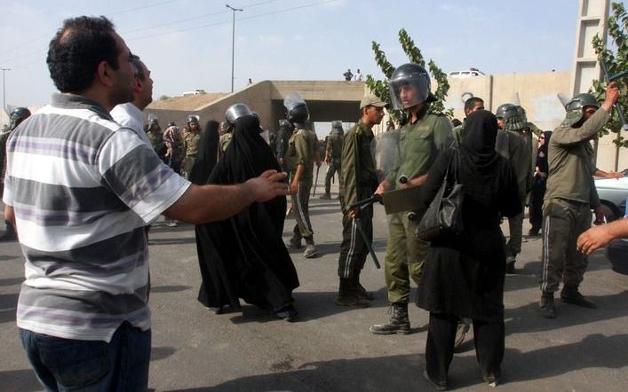 Iraanse betogers tegenover de oproerpolitie in Teheran. Volgens de Iraanse arts Sepehr Bostani is zich in Iran een ommekeer aan het voltrekken. „Er komt ver­andering; dat is slechts een kwestie van tijd.” - Foto EPA