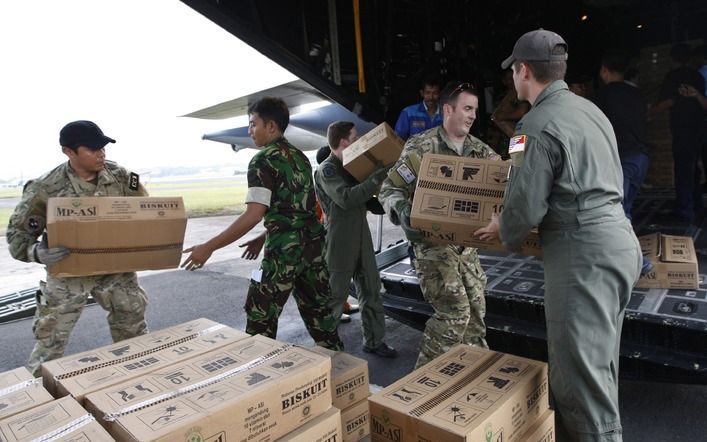 Amerikaanse en Indonesische militairen laden hulpgoederen in een vliegtuig. Foto EPA