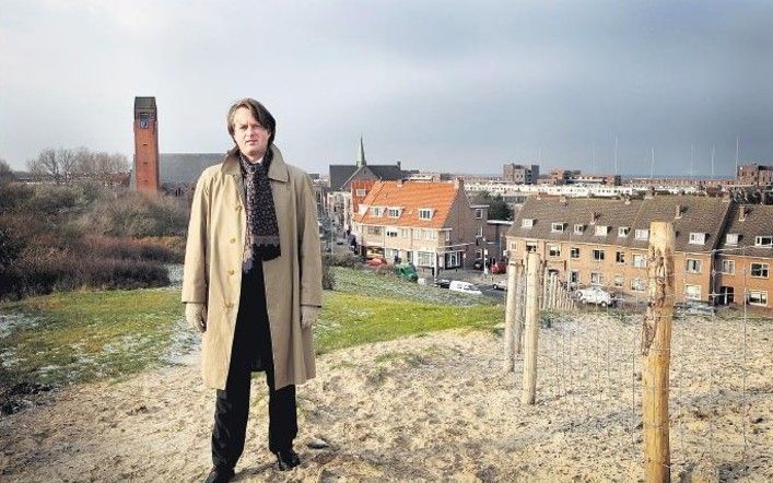 DEN HAAG – Ds. F. J. van Harten, predikant van de „meest bijzondere Samen op Wegwijkgemeente van Nederland”: Rondom de Julianakerk in Den Haag-Scheveningen. Links achter hem is de (hervormde) Prinses Julianakerk zichtbaar, rechts de (gereformeerde) Pniëlk