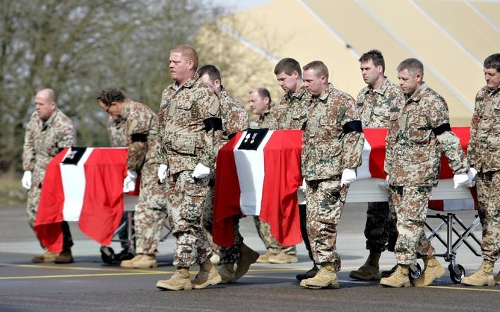 Deense militairen in Afghanistan brengen omgekomen collega's naar het vliegtuig. Foto EPA