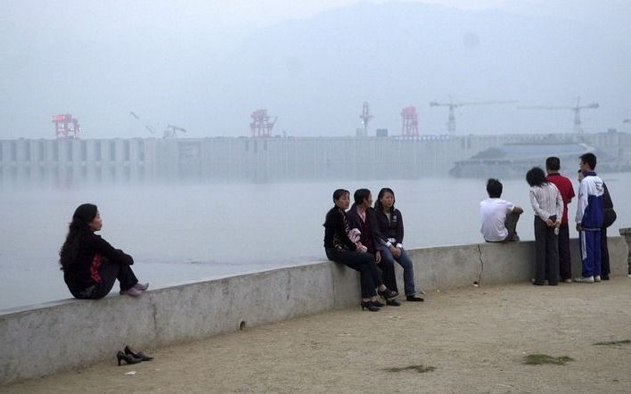 De Three Gorges Dam in de nevel. Meer dan 5,5 miljoen mensen moeten verhuizen vanwege de bouw van de dam.