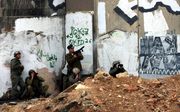 KALANDIYA - Israëlische soldaten nemen hun positie in tijdens botsingen met Palestijnen. Foto EPA