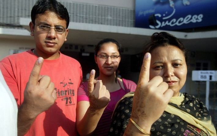 Inkt op de vingers van een familie in India geeft aan dat ze gestemd hebben. Foto EPA