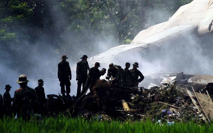 Reddingswerkers bij het wrak van het neergestorte vliegtuig. Foto EPA