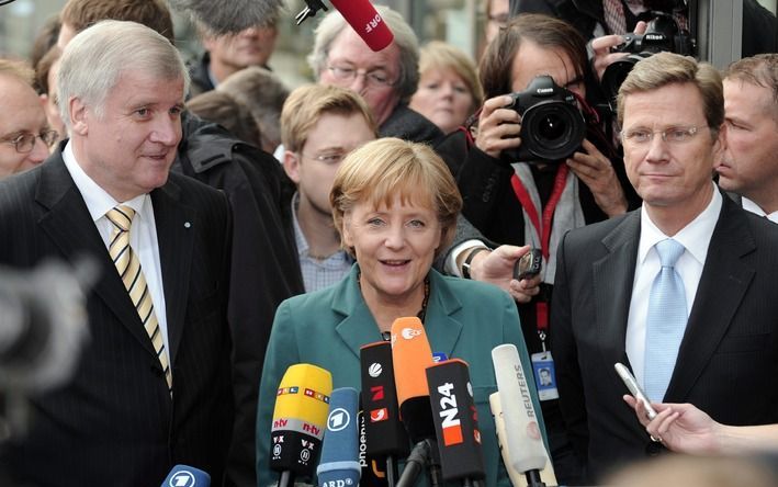 Angela Merkel (midden), FDP–leider Guido Westerwelle (rechts) en FDP'er Horst Seehofer staan de pers te woord. Foto EPA