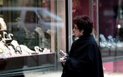 NEW YORK - Een vrouw bekijkt etalages in New York. De index van het consumentenvertrouwen van het researchinstituut Conference Board in New York is in de afgelopen maand gedaald tot 57,2 tegenover 62,8 in april. Dit is het laagste niveau van de afgelopen 