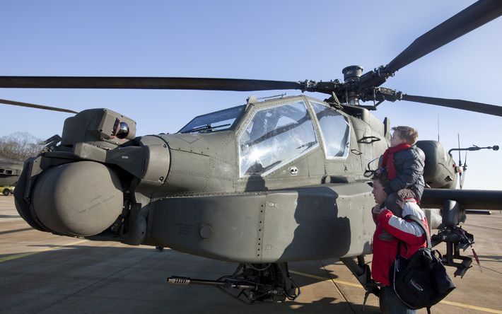 Inwoners van de Bommelerwaard kijken na het incident bij een Apachehelikopter. - Foto ANP