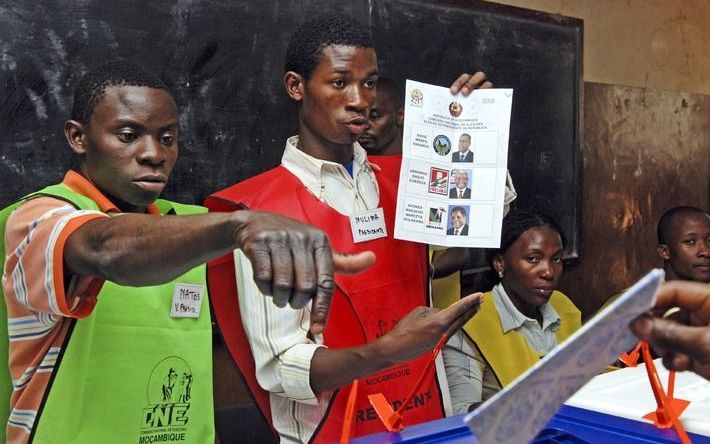 MAPUTO – Een verkiezingsmedewerker legt aan de kiezers uit hoe ze moeten stemmen voor een nieuwe president. Foto EPA