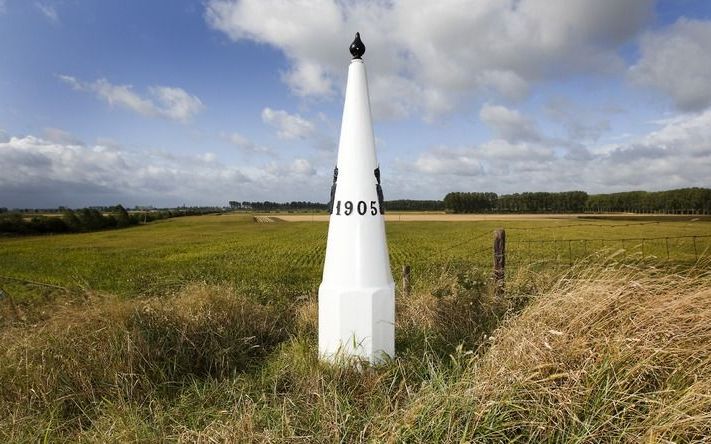 „Vlamingen zijn dus Latijnen, ook al spreken ze Nederlands. Nederlanders zijn beslist géén Latijnen.” Foto: De paal die de grens met België markeert op de dijk van de Hedwigepolder in Zeeuws-Vlaanderen. - Foto ANP