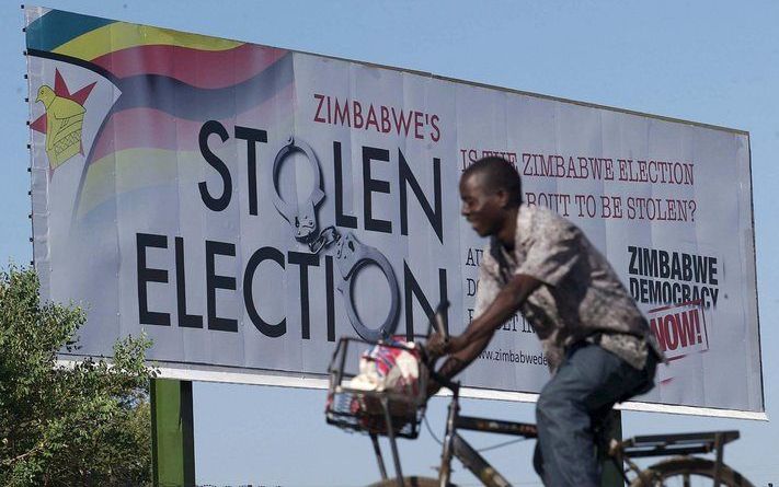 Een Zimbabwaan rijdt langs een door de oppositie geplaatst bord met de tekst ”Gestolen verkiezingen". Foto EPA