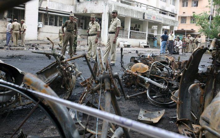 Indiase politieagenten bekijken de ravage die zaterdag ontstond in de westelijke stad Ahmedabad toen daar zestien bommen ontploften. Zeker 45 mensen kwamen bij de ex plosies om het leven. De aanslagen zijn vermoedelijk het werk van radicale moslimstrijder