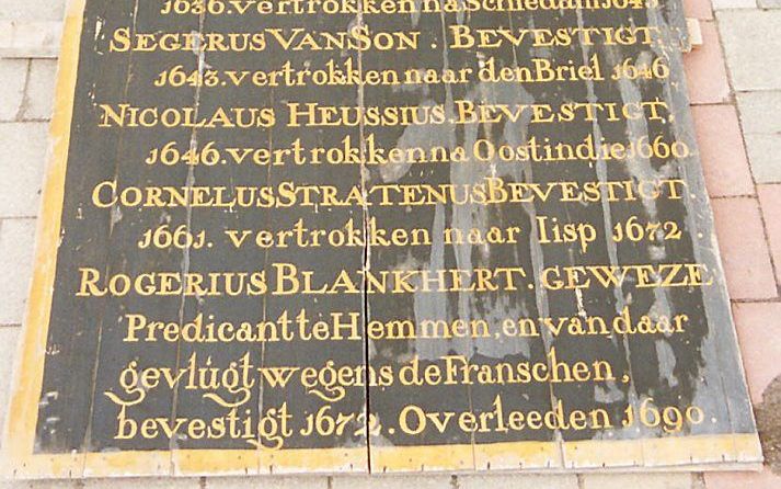 POORTUGAAL – Met zorg werden de vergulde letters aangebracht op het kolosale predikantenbord. Nu staan de panelen uit de hervormde kerk van Poortugaal afgedankt in een vochtige legerloods. Foto RD