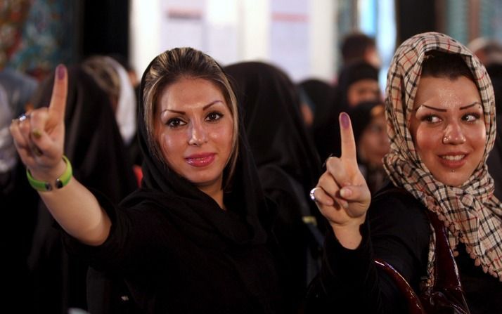 Iraanse vrouwen in Teheran laten het inkt op hun vinger zien, een teken dat ze gestemd hebben. Foto EPA