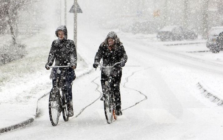 Fietsers trotseren maandag de zware sneeuwbuien in de omgeving van Zoetermeer. Foto ANP