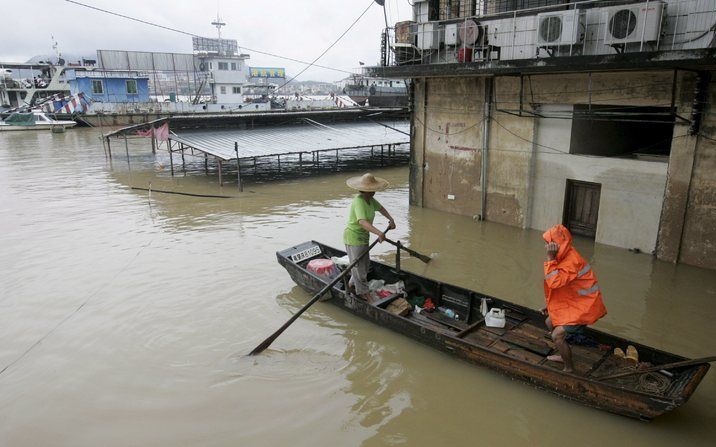 CHINA - Mensen in een boot nabij het overstroomde veerdiensteindpunt door de overstroomde Xijiang rivier in Zhaoqing. Foto EPA