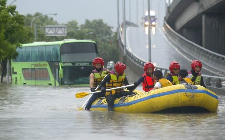 Reddingswerkers helpen gestrande Taiwanezen na ee tropische storm. Elf mensen kwamen door de storm om het leven. Foto's ANP