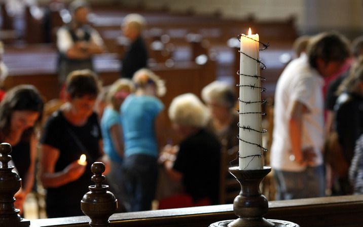 „Ik denk dat 90 procent normaal gesproken niet in de kerk komt”, fluistert ouderling J. Bos achter in de kerk. Foto ANP