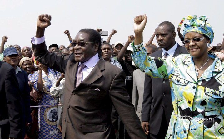 De Zimbabwaanse president Robert Mugabe maandag bij aankomst in Harare. Hij werd op het vliegveld onthaald door zingende en dansende aanhangers. Foto EPA.