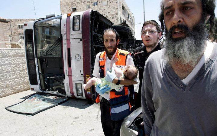 In het centrum van de Israëlische hoofdstad Jeruzalem brak woensdagmorgen paniek uit op straat toen een bulldozer inreed op een volle passagiersbus. Er zouden ook enkele doden zijn gevallen. Foto EPA