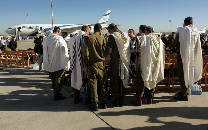 Het Israëlische team biddend op luchthaven Ben Gurion. Foto EPA.