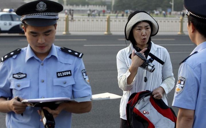 PEKING – Een politieman verhinderde donderdagmorgen een journalist foto’s te maken van het Tiananmenplein in Peking. Twintig jaar na dato is nog steeds niet bekend wat daar op 4 juni 1989 gebeurde. Foto EPA